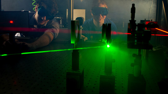 Students experiment with laser in optics lab.